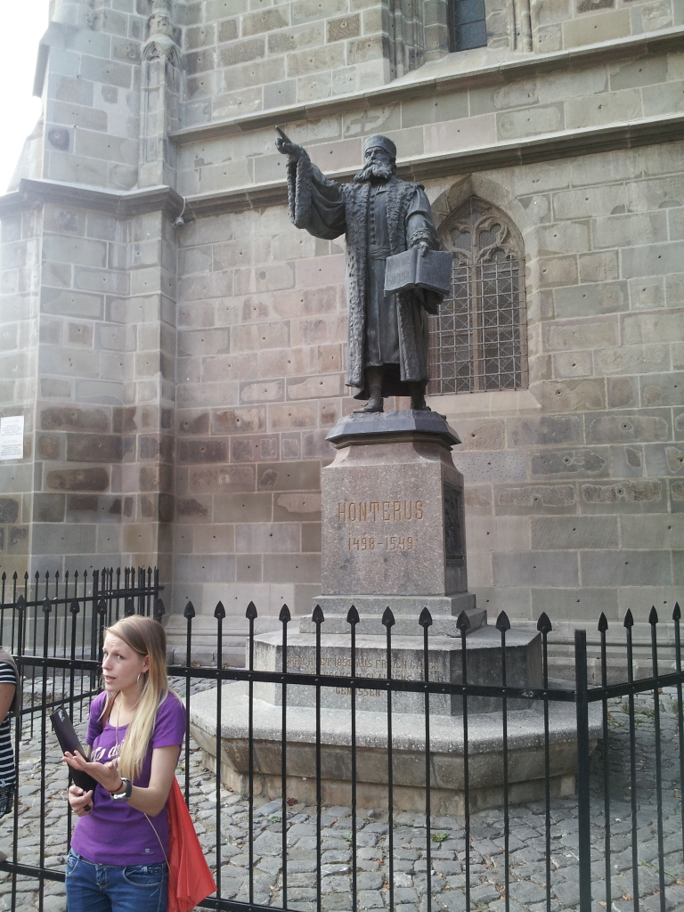 The tour guide and a statue of Honterus in front of the Black Church